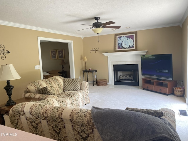 living room with visible vents, carpet, a ceiling fan, crown molding, and a fireplace