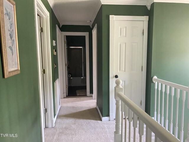hallway featuring carpet floors, ornamental molding, an upstairs landing, and baseboards