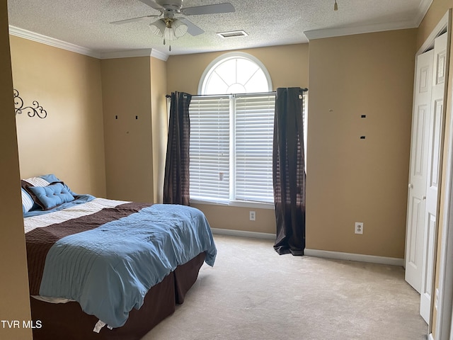 bedroom featuring light carpet, a textured ceiling, baseboards, visible vents, and ornamental molding