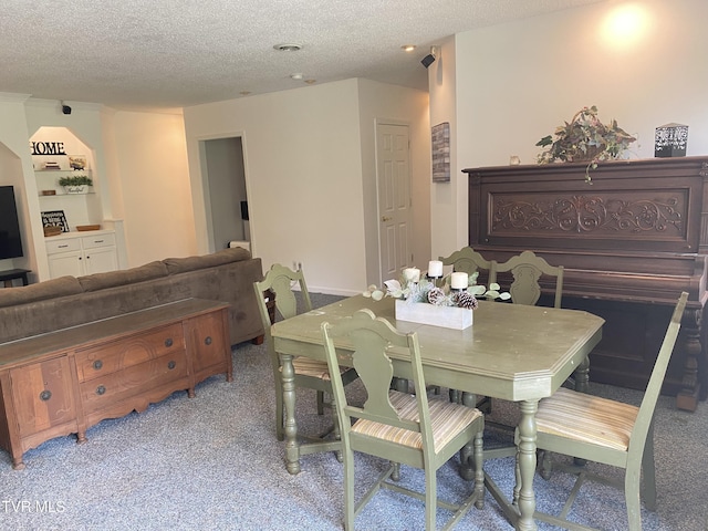 dining space with light carpet and a textured ceiling