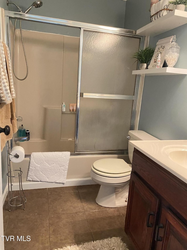 full bath with tile patterned floors, vanity, shower / bath combination with glass door, and toilet