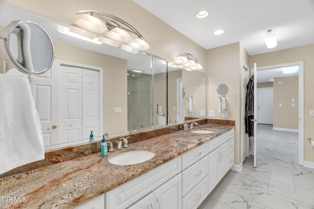 bathroom featuring double vanity, a shower stall, marble finish floor, and a sink