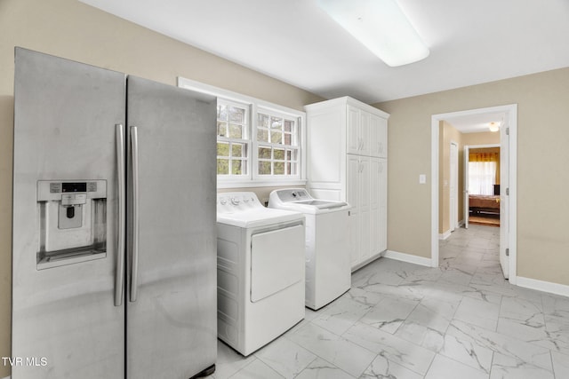 laundry room featuring plenty of natural light, marble finish floor, washer and dryer, and cabinet space