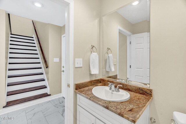 bathroom featuring vanity, marble finish floor, baseboards, toilet, and recessed lighting