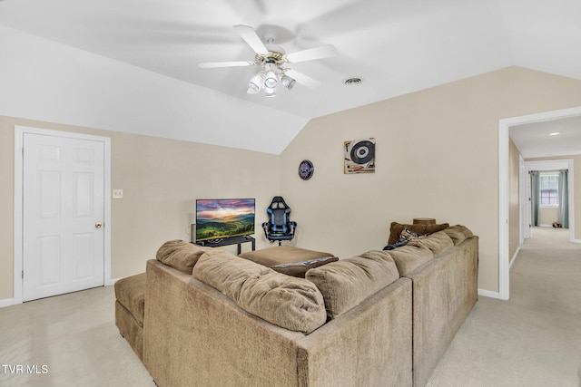 living room featuring baseboards, lofted ceiling, ceiling fan, and light carpet