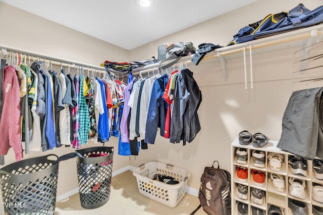 walk in closet with carpet flooring