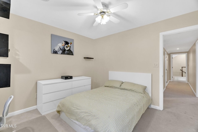 bedroom with ceiling fan, baseboards, and light carpet