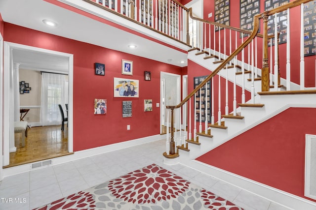 stairs with recessed lighting, visible vents, tile patterned floors, and baseboards