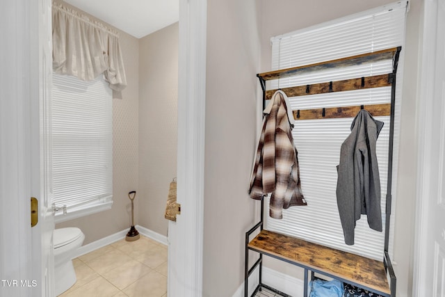 bathroom with baseboards, tile patterned flooring, and toilet