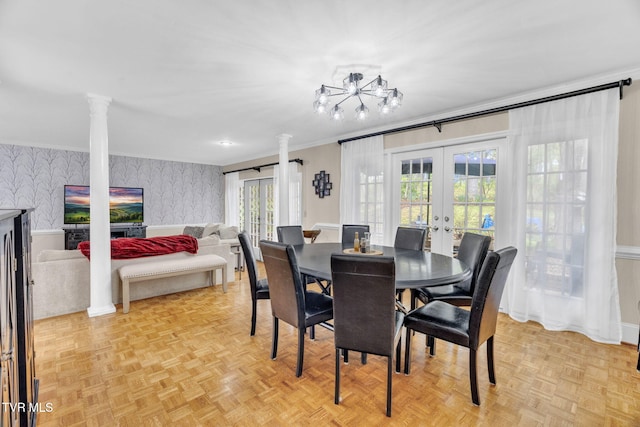 dining space with wallpapered walls, ornate columns, ornamental molding, french doors, and a chandelier