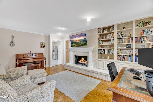 living room featuring a brick fireplace, built in shelves, baseboards, and ornamental molding