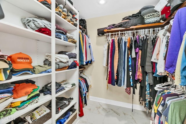 walk in closet with marble finish floor