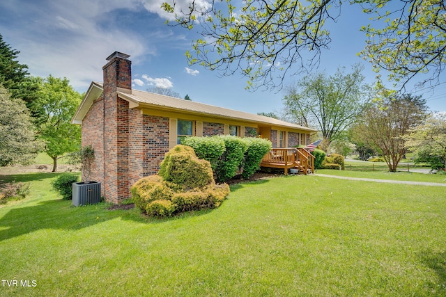 exterior space with a chimney, central air condition unit, a yard, metal roof, and brick siding