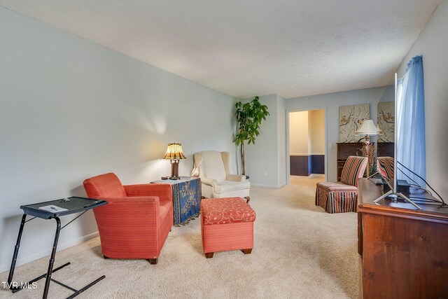 sitting room featuring carpet floors and baseboards