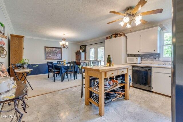 kitchen with a wealth of natural light, black dishwasher, white microwave, and light countertops