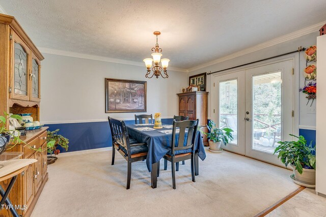 dining room featuring french doors, crown molding, baseboards, a chandelier, and light colored carpet