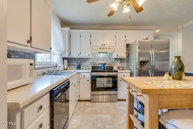 kitchen with under cabinet range hood, appliances with stainless steel finishes, a sink, and light countertops