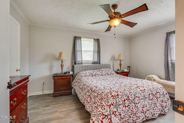 bedroom with baseboards, a ceiling fan, wood finished floors, and crown molding