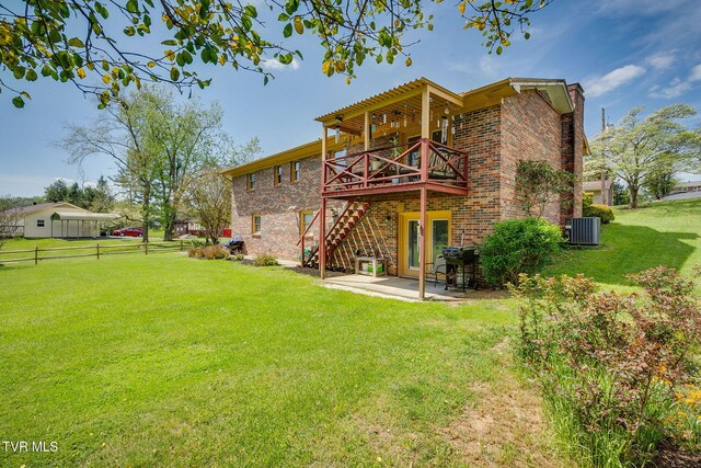 back of property with a lawn, fence, cooling unit, a wooden deck, and brick siding