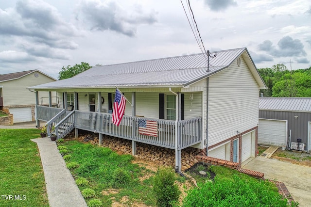 view of front of home with a porch, driveway, and metal roof