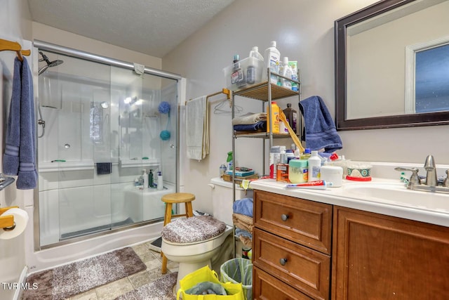 full bathroom with vanity, a textured ceiling, toilet, and a shower stall