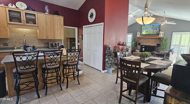 304 Tunnel Dr, Dryden, VA 24243 - kitchen with a brick fireplace, tasteful backsplash, a breakfast bar, a ceiling fan, and a toaster
