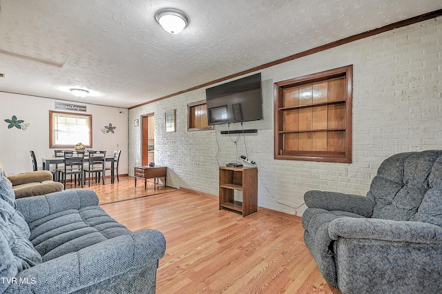2856 Watauga Rd, Johnson City, TN 37601 - living room featuring light wood-type flooring, brick wall, a textured ceiling, and crown molding