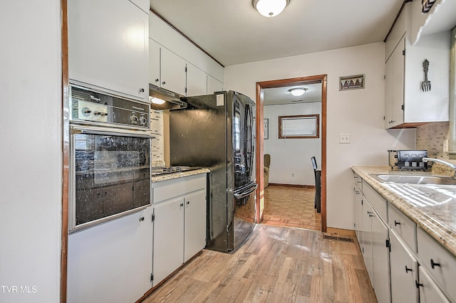 2856 Watauga Rd, Johnson City, TN 37601 - kitchen with black appliances, under cabinet range hood, light countertops, and light wood-type flooring