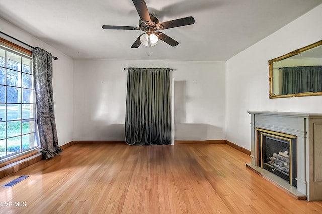 2856 Watauga Rd, Johnson City, TN 37601 - unfurnished living room with ceiling fan, baseboards, light wood-style floors, and a fireplace with raised hearth