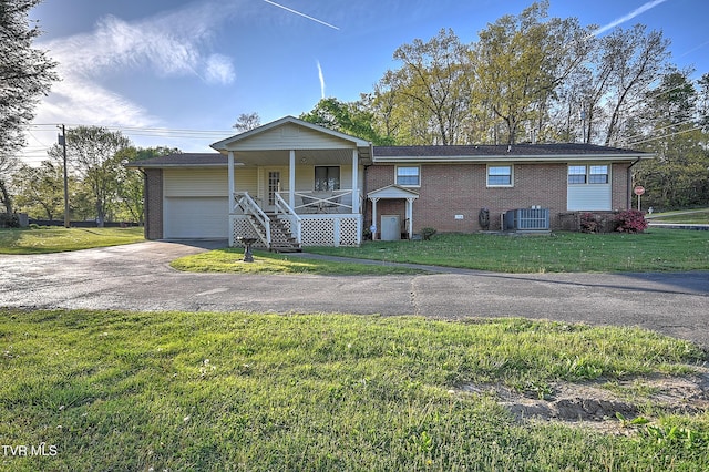 2856 Watauga Rd, Johnson City, TN 37601 - view of front of house featuring central AC unit, an attached garage, a porch, a front yard, and brick siding