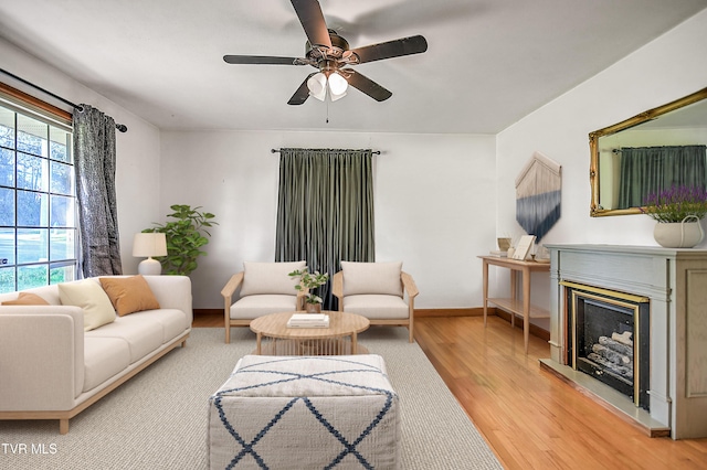 2856 Watauga Rd, Johnson City, TN 37601 - living room featuring baseboards, a fireplace with raised hearth, light wood-style floors, and ceiling fan