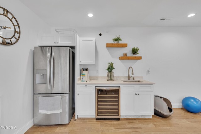 2040 Happy Valley Rd, Limestone, TN 37681 - bar featuring visible vents, beverage cooler, wood tiled floor, stainless steel fridge, and a sink