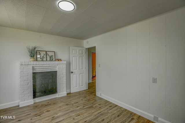 908 Columbia Rd, Bristol, TN 37620 - unfurnished living room with wood finished floors, a brick fireplace, and baseboards