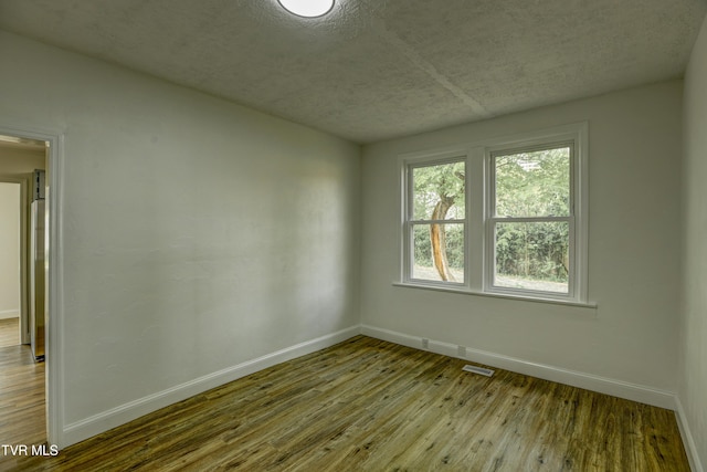 908 Columbia Rd, Bristol, TN 37620 - empty room with a textured ceiling, hardwood / wood-style floors, visible vents, and baseboards