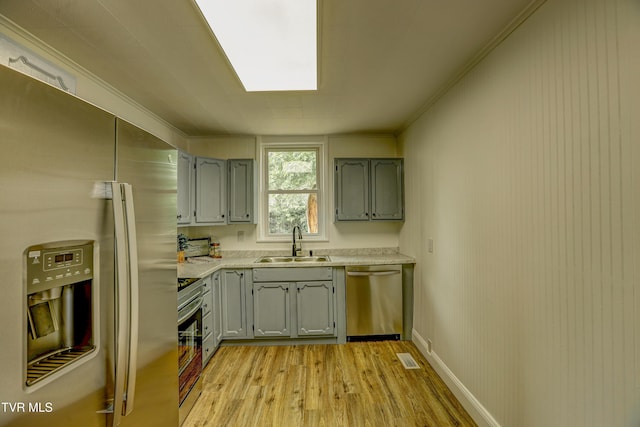 908 Columbia Rd, Bristol, TN 37620 - kitchen with stainless steel appliances, a sink, light wood-type flooring, gray cabinets, and light countertops