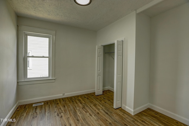 908 Columbia Rd, Bristol, TN 37620 - unfurnished bedroom with baseboards, wood finished floors, visible vents, and a textured ceiling