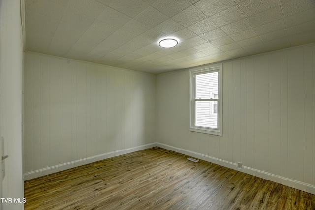 908 Columbia Rd, Bristol, TN 37620 - spare room featuring hardwood / wood-style floors, wooden walls, baseboards, and visible vents