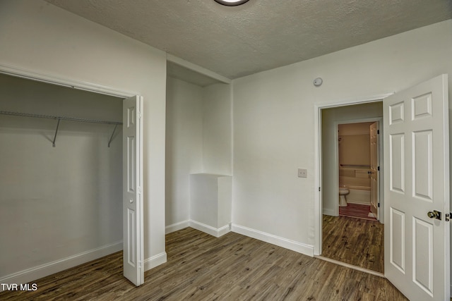 908 Columbia Rd, Bristol, TN 37620 - unfurnished bedroom featuring a textured ceiling, wood finished floors, a closet, and baseboards
