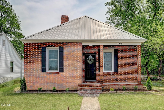 908 Columbia Rd, Bristol, TN 37620 - view of front of house featuring a chimney, a front lawn, fence, metal roof, and brick siding