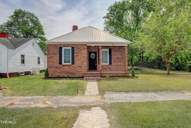 908 Columbia Rd, Bristol, TN 37620 - bungalow-style house featuring a chimney, a front lawn, brick siding, and metal roof