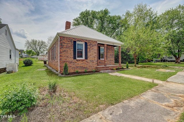 908 Columbia Rd, Bristol, TN 37620 - view of front facade featuring brick siding, a front lawn, a chimney, and covered porch