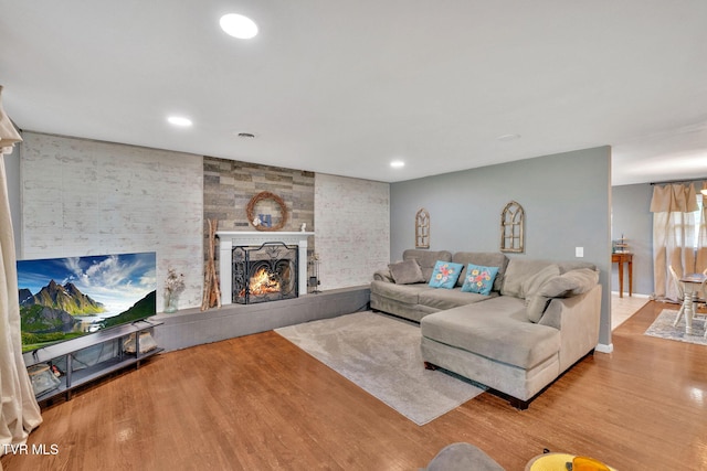 living area with recessed lighting, wood finished floors, and a fireplace