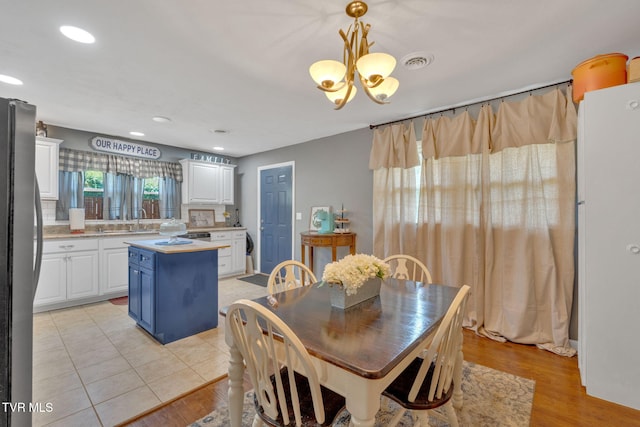 dining space featuring recessed lighting, an inviting chandelier, visible vents, and light wood-type flooring