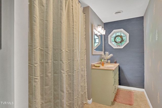 bathroom featuring visible vents, baseboards, and vanity