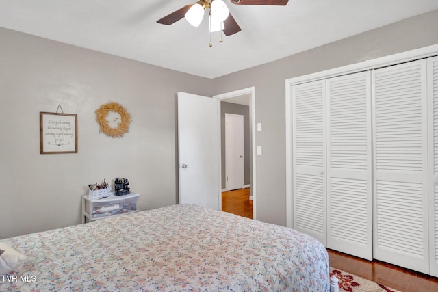 bedroom featuring a ceiling fan, a closet, and wood finished floors