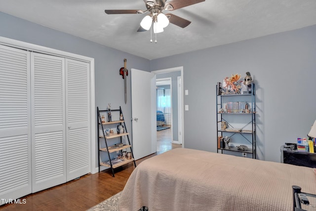 bedroom featuring baseboards, ceiling fan, wood finished floors, and a closet