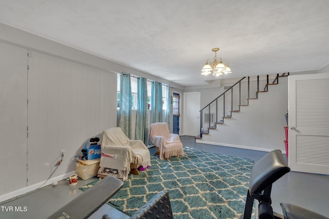 sitting room with baseboards, stairs, and a chandelier
