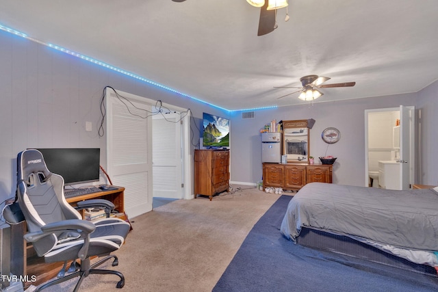 bedroom with light colored carpet, ceiling fan, ensuite bath, and visible vents