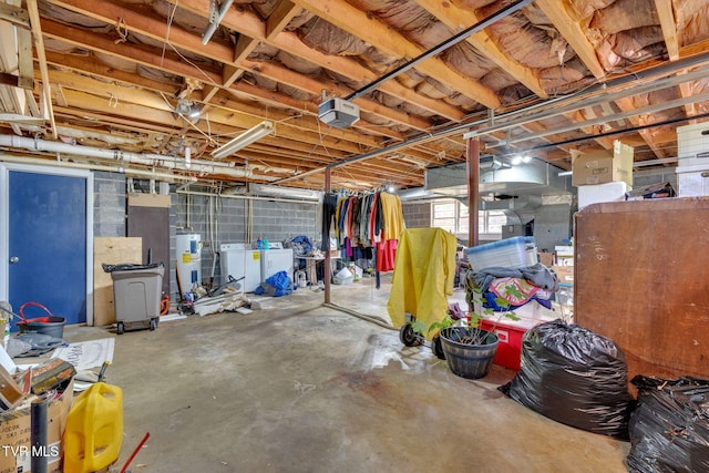 basement featuring water heater and washing machine and clothes dryer
