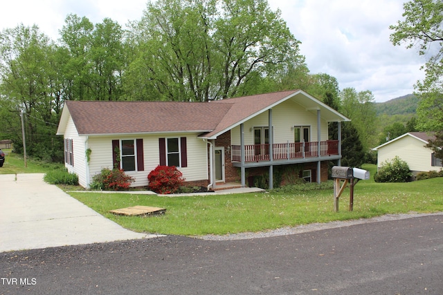 single story home with driveway, roof with shingles, and a front yard
